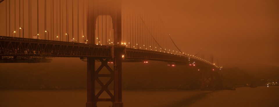 Cars drive along the Golden Gate Bridge under a wildfire-induced, smoke